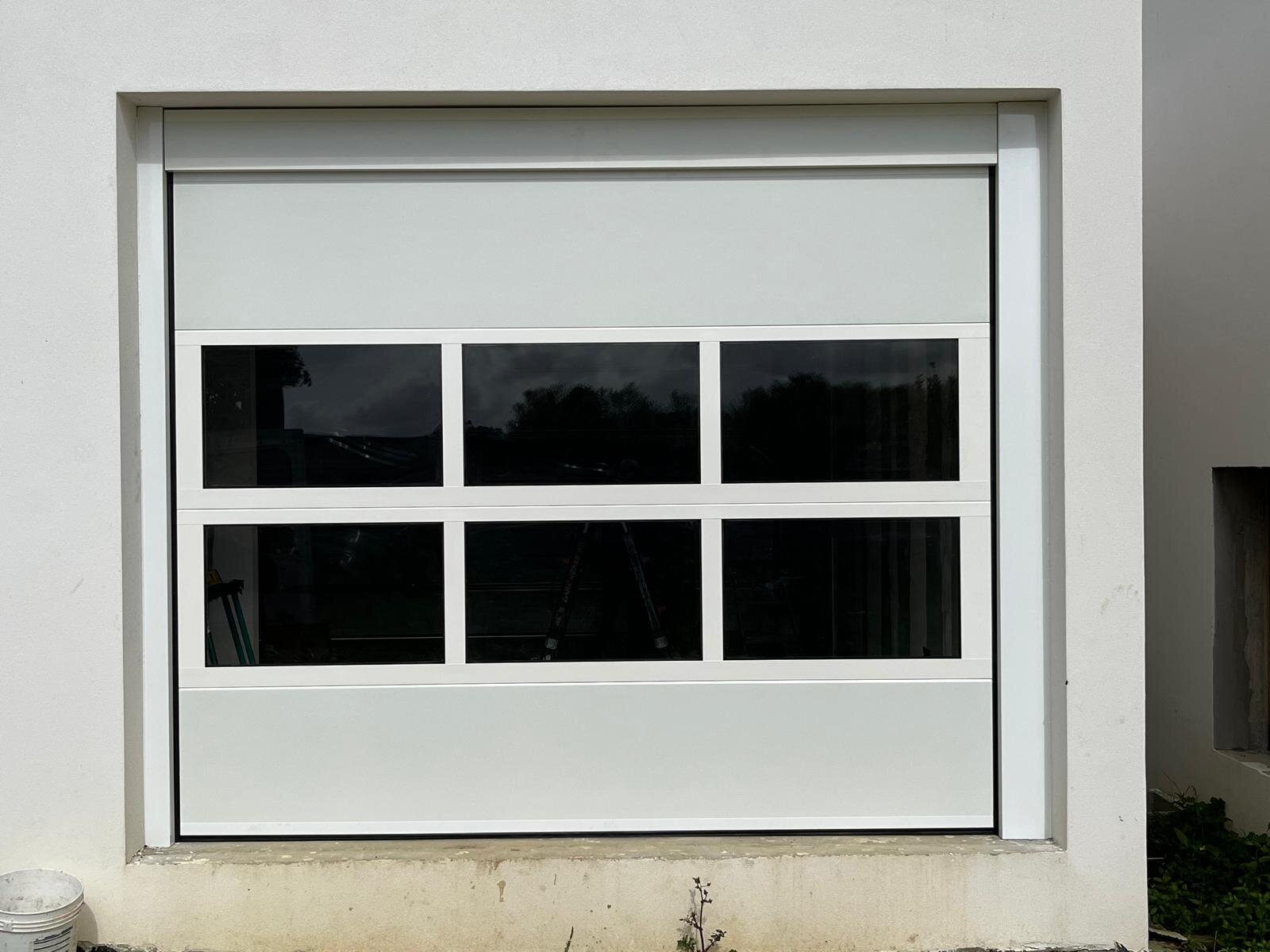 Puerta seccional blanca con ventanas panorámicas en A Coruña